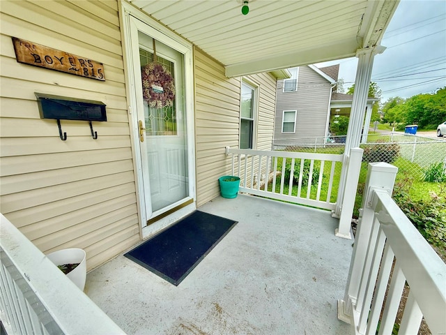 property entrance with a porch and fence