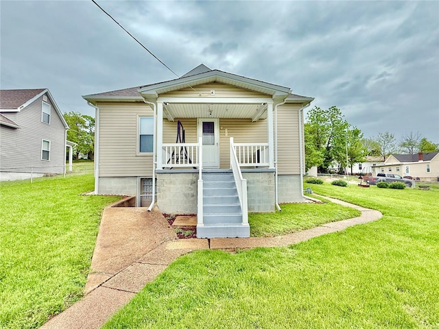 rear view of property with a porch, a yard, and stairway