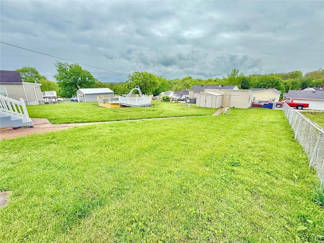 view of yard featuring an outdoor structure, a shed, and fence