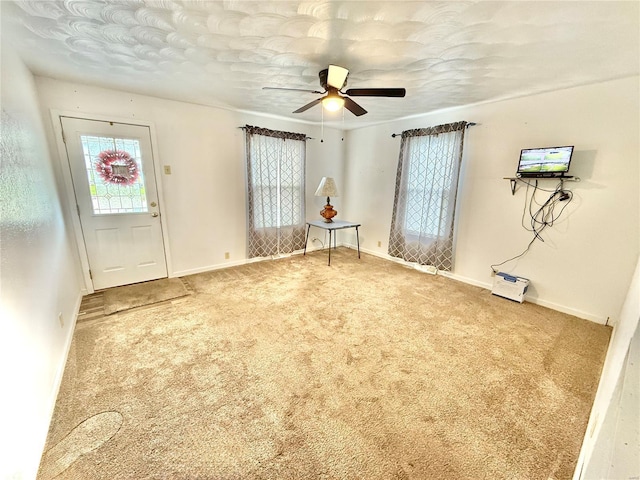 interior space featuring baseboards, carpet flooring, and ceiling fan