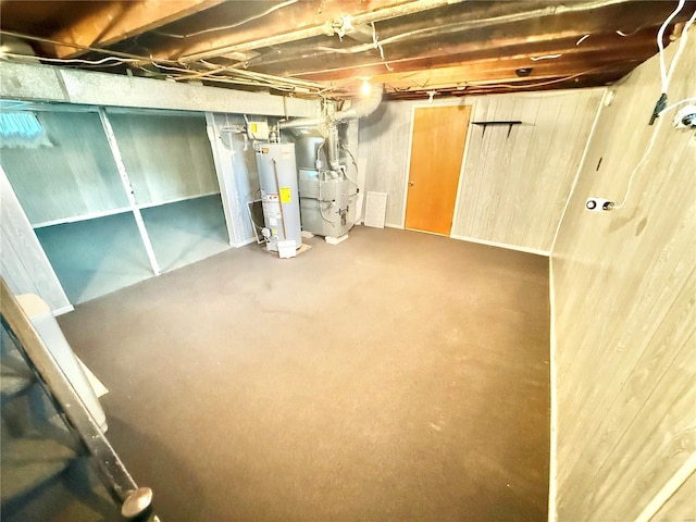 unfinished below grade area with heating unit, visible vents, and gas water heater