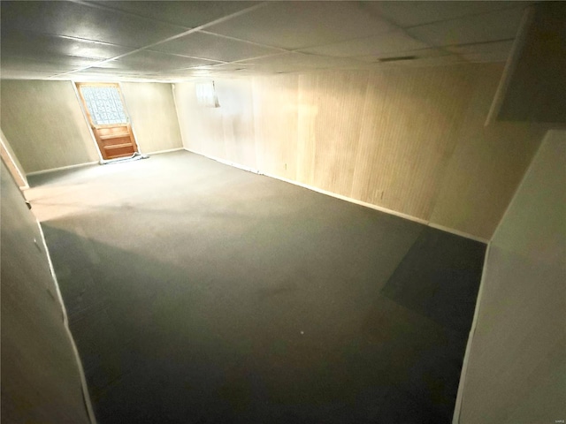 below grade area with carpet flooring, baseboards, and a paneled ceiling