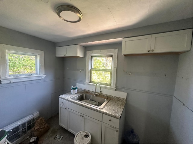 kitchen with a sink, white cabinets, and light countertops