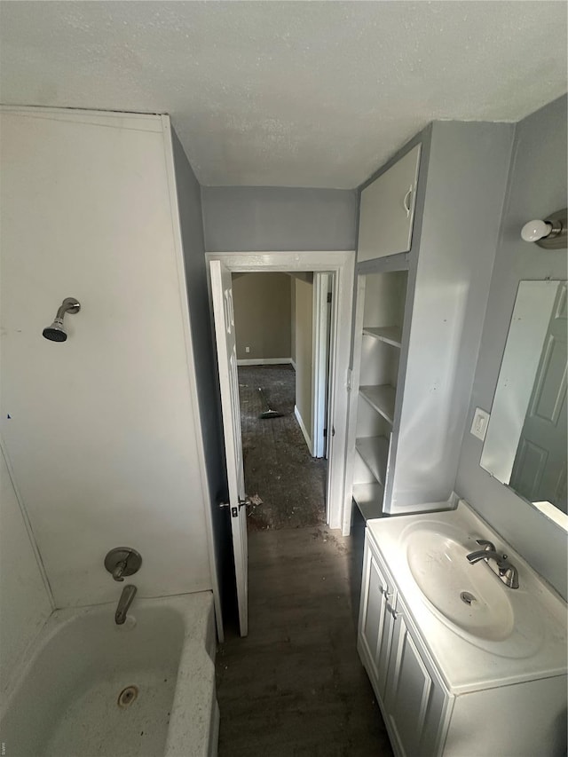 full bath with vanity, a textured ceiling, and wood finished floors