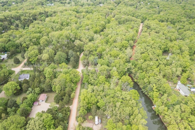 drone / aerial view featuring a wooded view and a water view