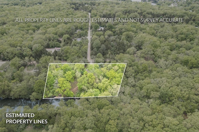 drone / aerial view featuring a wooded view and a water view