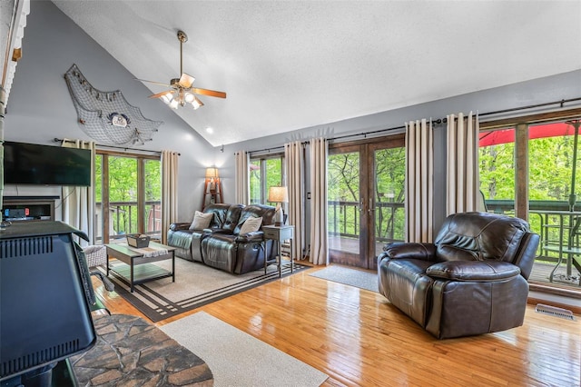 living room featuring ceiling fan, high vaulted ceiling, visible vents, and wood finished floors