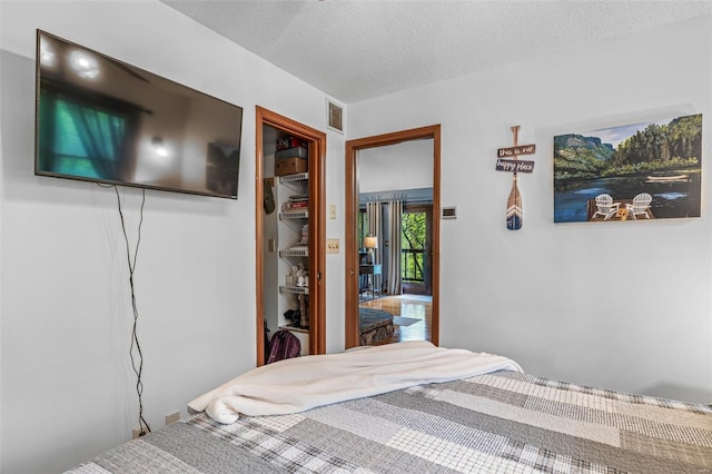bedroom with a textured ceiling and visible vents