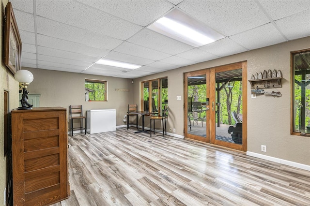 sitting room with wood finished floors, french doors, baseboards, and a paneled ceiling
