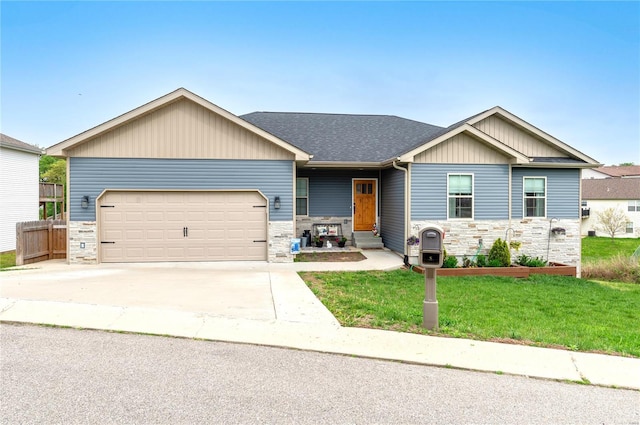 view of front of house featuring an attached garage, stone siding, board and batten siding, a front yard, and driveway