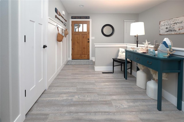 foyer featuring baseboards and wood finished floors