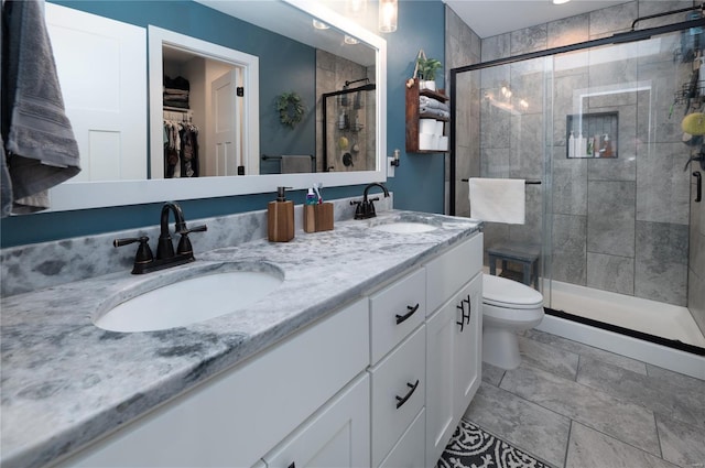 full bath with a sink, double vanity, toilet, and a stall shower