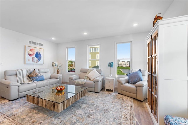 living area featuring recessed lighting, light wood-style flooring, and visible vents