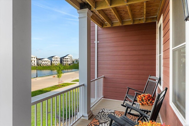 balcony featuring a residential view and a water view