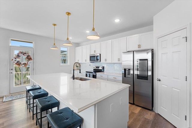 kitchen featuring a sink, a center island with sink, white cabinets, and stainless steel appliances
