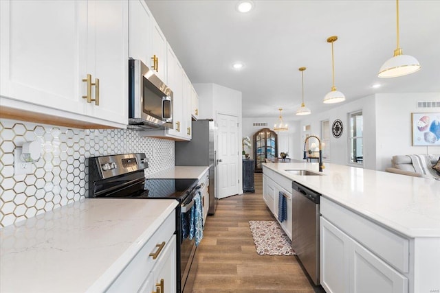 kitchen featuring appliances with stainless steel finishes, a sink, white cabinetry, visible vents, and dark wood-style floors