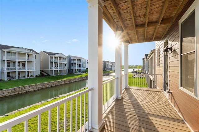 balcony featuring a residential view and a water view