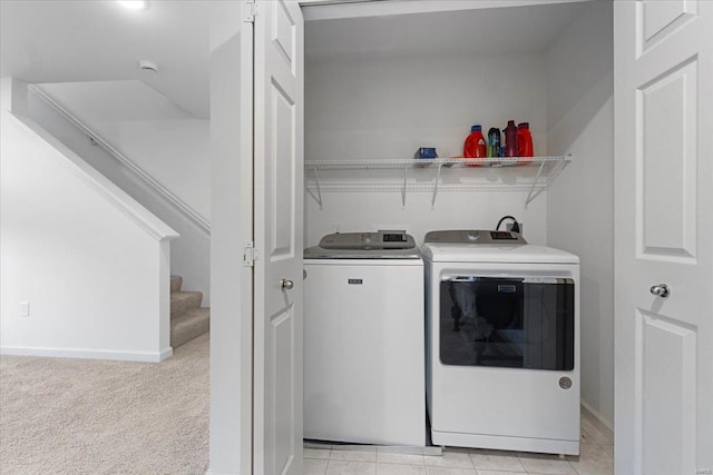 clothes washing area with separate washer and dryer, laundry area, and baseboards