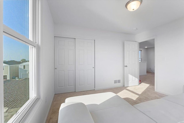 bedroom featuring carpet floors, baseboards, visible vents, and a closet