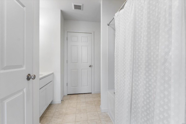hallway with visible vents and light tile patterned floors