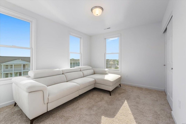 living room featuring visible vents, baseboards, and light carpet