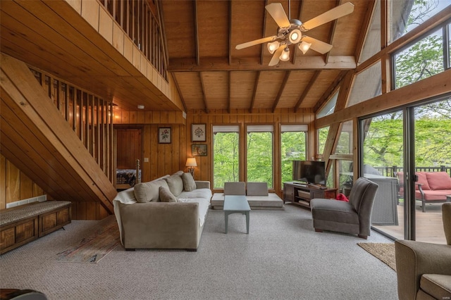 living room featuring wooden ceiling, wooden walls, carpet flooring, and beamed ceiling