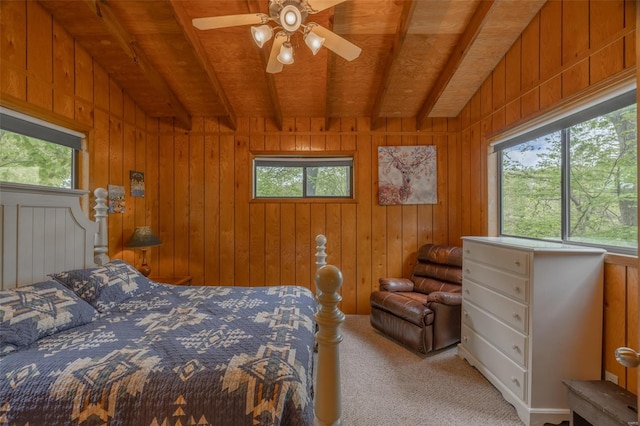 carpeted bedroom with beam ceiling, wood walls, and wood ceiling