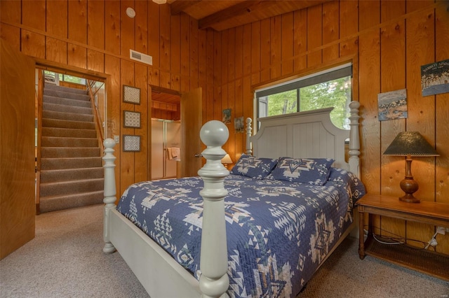 bedroom featuring wood ceiling, beam ceiling, carpet floors, visible vents, and wood walls