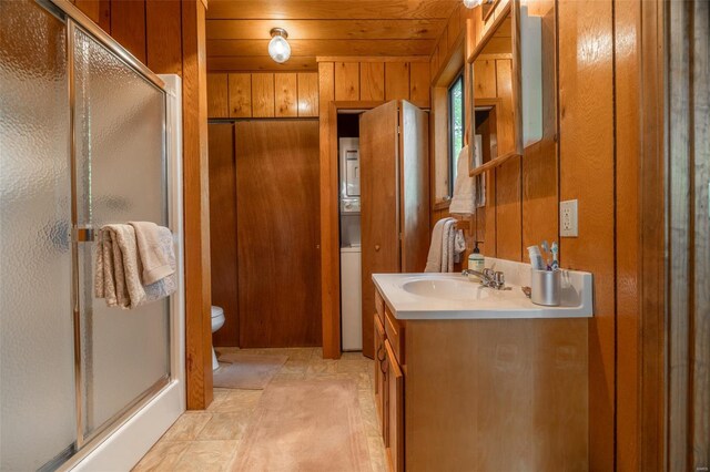 full bath featuring toilet, vanity, wooden walls, and a shower stall