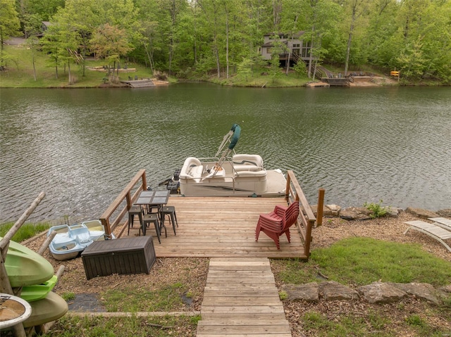 view of dock featuring a water view and a forest view