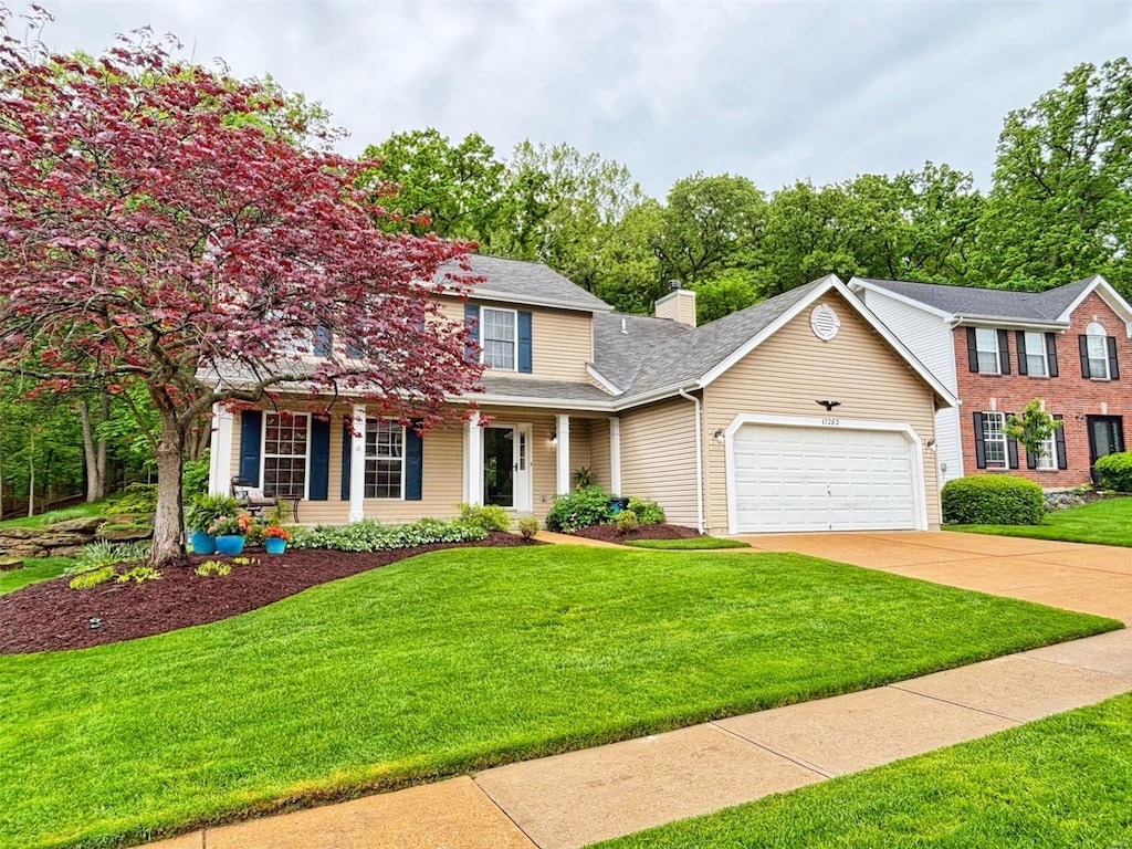 view of front facade featuring a shingled roof, an attached garage, driveway, and a front lawn