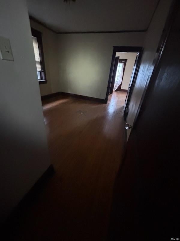 spare room featuring baseboards and wood finished floors