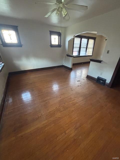 interior space with ceiling fan, baseboards, and wood finished floors