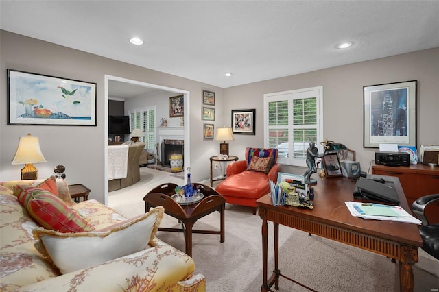 living area featuring a fireplace, light carpet, and recessed lighting