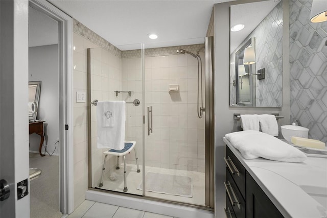 bathroom with a stall shower, recessed lighting, tile patterned flooring, and vanity