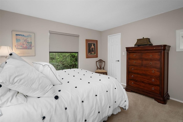 bedroom with baseboards and light carpet
