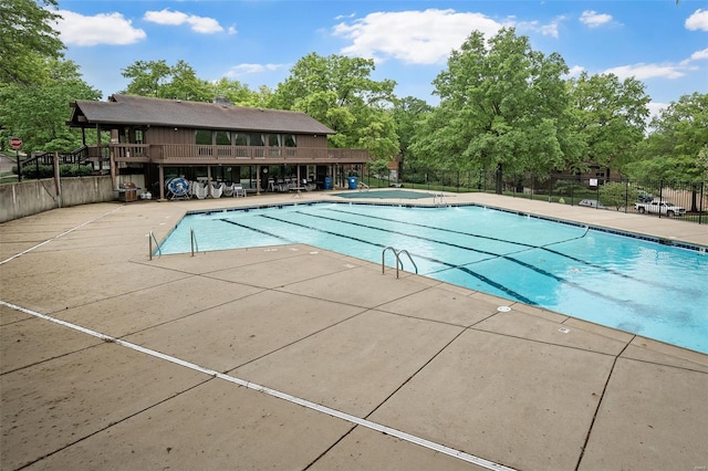 pool with a patio area and fence