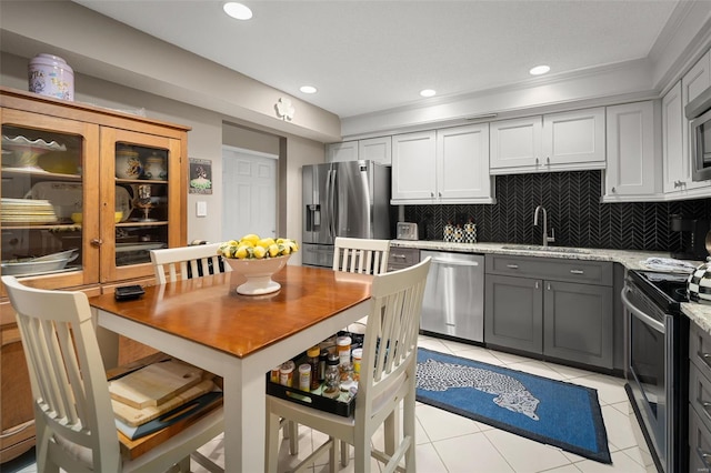 kitchen featuring a sink, gray cabinets, appliances with stainless steel finishes, and tasteful backsplash