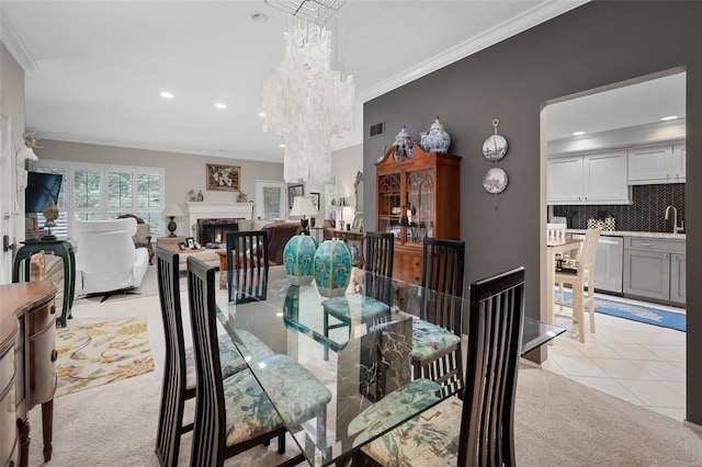 dining room with visible vents, ornamental molding, a warm lit fireplace, and light colored carpet