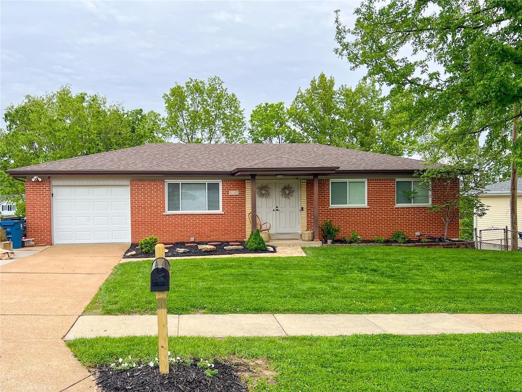 ranch-style house featuring a front yard, a garage, brick siding, fence, and concrete driveway