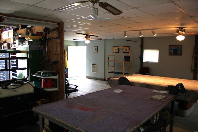 dining area with baseboards, a ceiling fan, heating unit, and a drop ceiling