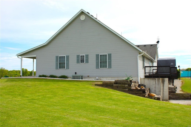 back of property featuring a lawn, a wooden deck, and central air condition unit