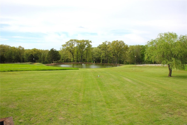 view of home's community featuring a lawn, a water view, and golf course view