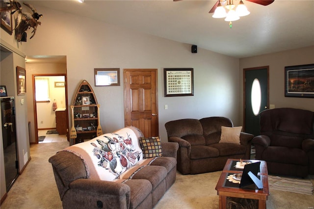 living area with ceiling fan, lofted ceiling, and light colored carpet