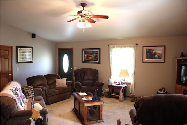 living room with a ceiling fan, vaulted ceiling, and light carpet