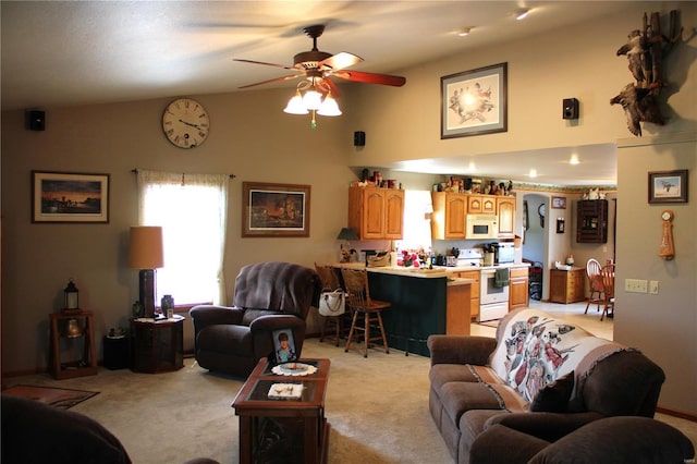 living area with high vaulted ceiling, ceiling fan, and light colored carpet
