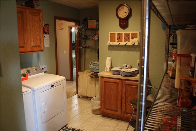 laundry area featuring cabinet space, light tile patterned floors, and washer and dryer