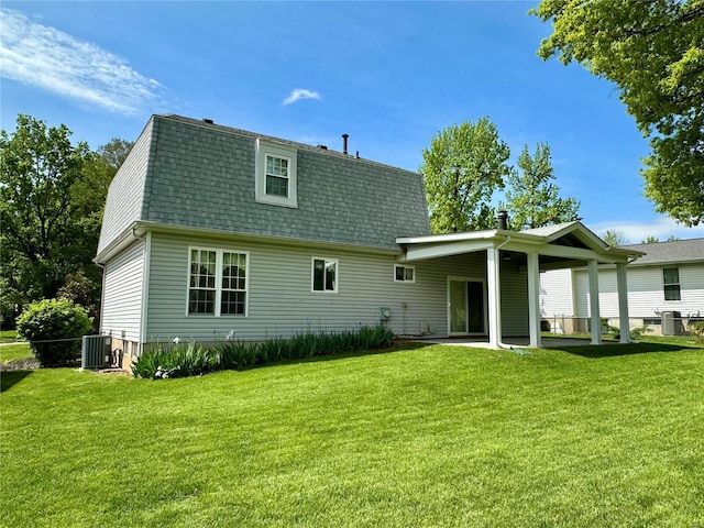 rear view of property with roof with shingles, central AC unit, a yard, and a patio area
