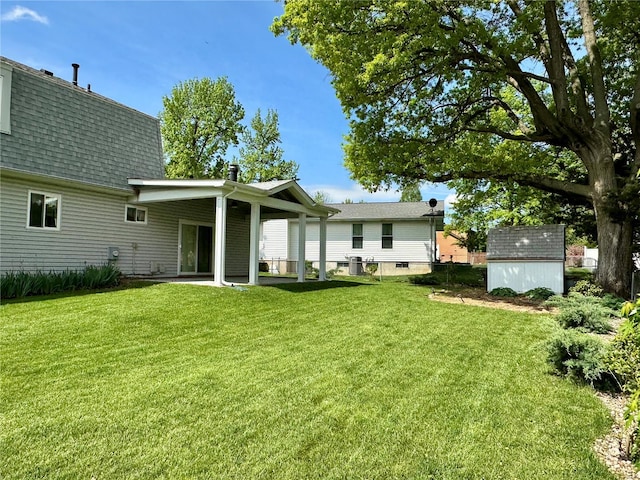 back of property with an outbuilding, a yard, and a shed