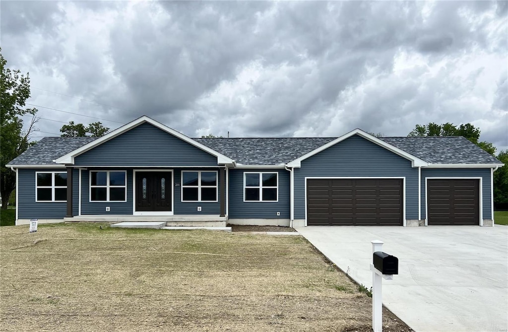 ranch-style house featuring an attached garage, a front lawn, a porch, and concrete driveway